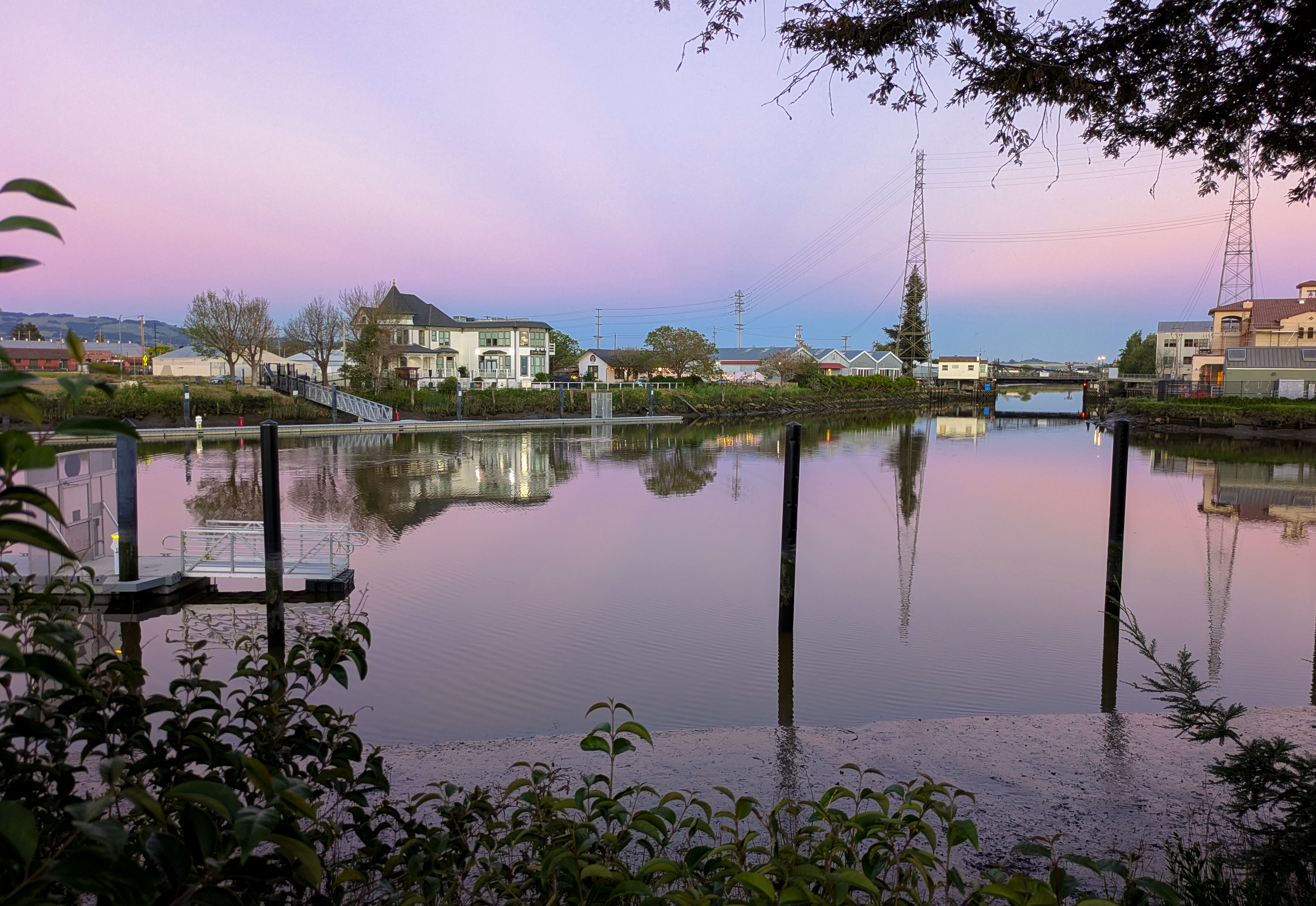 Petaluma waterfront at dusk, pink and purple sky reflected in calm water